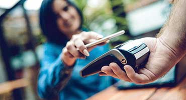 Woman using a phone to make a purchase.