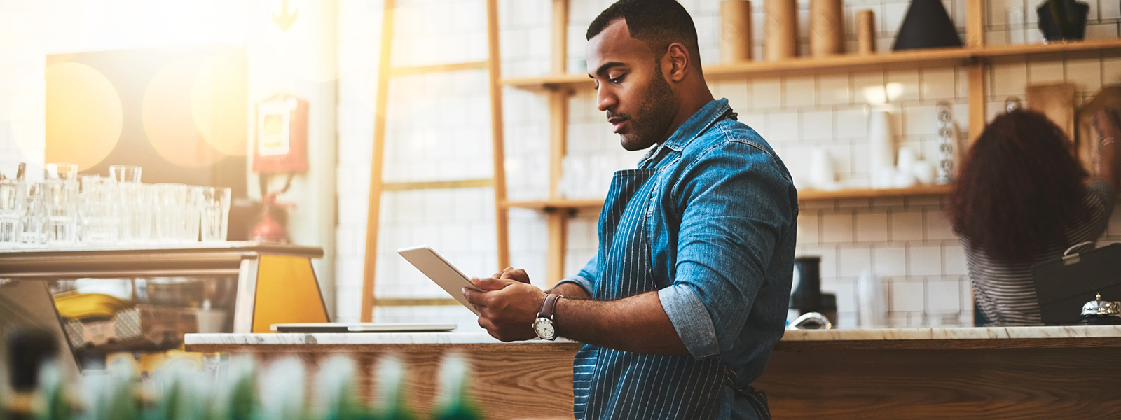 Restaurant owner at counter purchasing supplies online.