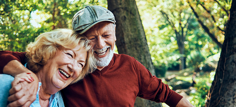 older couple in woods hugging