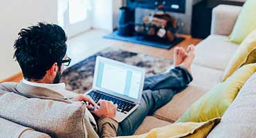 Man doing his banking online from his sofa.